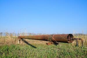 Gas pipeline through irrigation canal in a protective steel pipe. photo