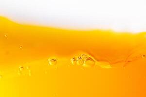 Close up bright orange juice splash texture for health and nature waves, Beautiful waves curve and little bubbles smooth for garphic design and background photo