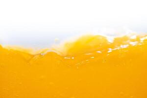 Close up bright orange juice splash texture for health and nature waves, Beautiful waves curve and little bubbles smooth for garphic design and background photo