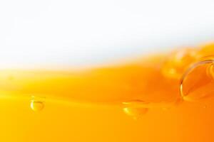 Close up bright orange juice splash texture for health and nature waves, Beautiful waves curve and little bubbles smooth for garphic design and background photo