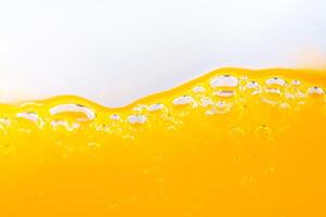 Close up bright orange juice splash texture for health and nature waves, Beautiful waves curve and little bubbles smooth for garphic design and background photo