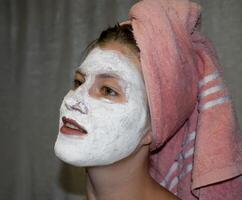 Cosmetic white face mask of toothpaste. Woman in white cosmetic mask photo