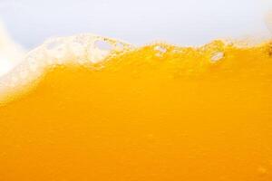 Close up bright orange juice splash texture for health and nature waves, Beautiful waves curve and little bubbles smooth for garphic design and background photo