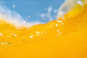 Close up bright orange juice splash texture for health and nature waves, Beautiful waves curve and little bubbles smooth for garphic design and background photo