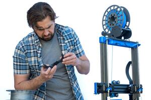 Man looking at supports resulting from a 3D print. photo