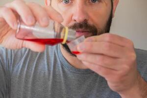 Person measuring the cough syrup he is going to drink. photo