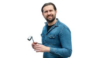 Argentinian mechanic posing on a white background while holding a tool. photo