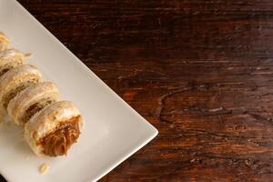 Composition of Argentine snack with cannon of dulce de leche and cup with infusion. photo