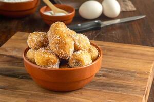 frito buñuelos cubierto en azúcar. típico de argentino hecho en casa pasteles foto