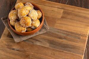 frito buñuelos cubierto en azúcar. típico de argentino hecho en casa pasteles foto