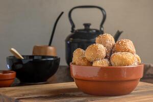 Argentine fritters coated in sugar accompanied by mate and kettle. photo