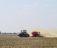 tractor paseos en el campo y hace el fertilizante dentro el asique foto