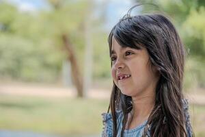 Beautiful little girl pictured in a park while talking. photo