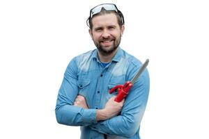 Young welder holding welding clamp, electrodes and has safety glasses on his head. photo