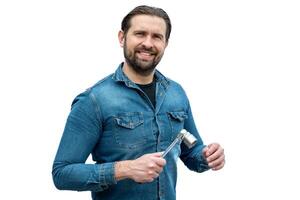 Young mechanic holding a tool with his hand. photo