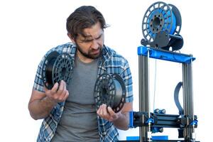 Man selecting filaments to make a 3D print. photo