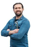 Young mechanic looking at camera smiling and relaxed with a pipe wrench in his hand. photo