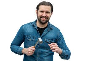 Young auto mechanic posing on white background with a tool in his hands. photo