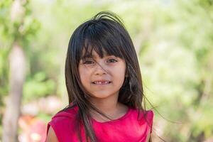 retrato de un hermosa Hispano niña en un parque. foto