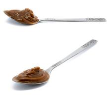 Dulce de leche in a metal spoon on isolated background. photo