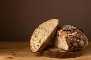 sano y muy crujiente de masa fermentada un pan descansando en un tablero. foto