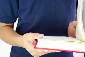 el hombre sostiene un libro y es leyendo él. educación, investigación, conocimiento y abierto arriba el mundo concepto. foto