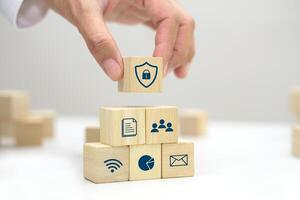 Hand holding a wooden block cube with security icon symbol. Business strategy and target of business. photo