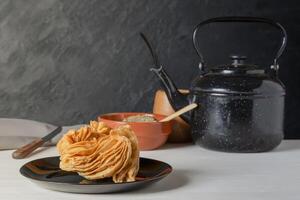 Kettle and mate, accompanied by a traditional Argentine fry called Pastelito photo