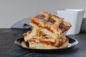 Quince cake on wooden table accompanied by cup. photo