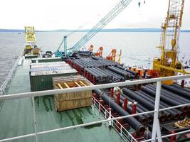 el cubierta laico barcaza. tubería y levantamiento grúas en el barco. equipo para tendido un tubería en el fondo del mar foto