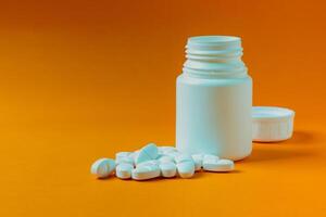 Pill container on an orange background. photo