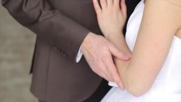 Wedding couple holding hands, happy groom and bride. Groom and brides hands with rings, close up video