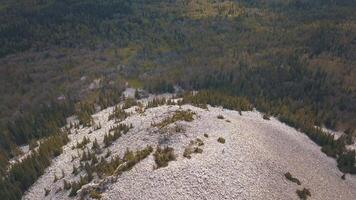 Rocky hill strewn with white stones over mixed forest. Clip. Aerial view of Russian landscape video