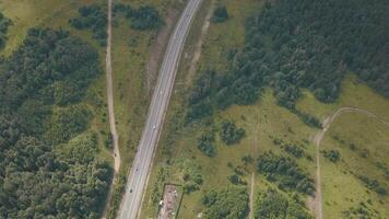 Aerial view of the road with moving cars. Clip. Road through the fields and forest video