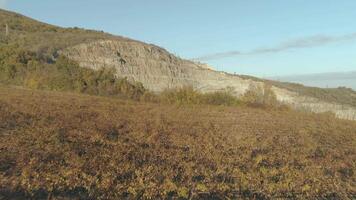 Herbst Feld in der Nähe von ein Kreide Steinbruch gegen Blau Himmel. Schuss. klar und warm Abend video