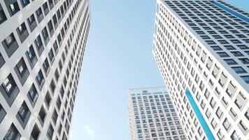 Angle view of white skyscrapers against blue sky. Frame. Fantastic below view video