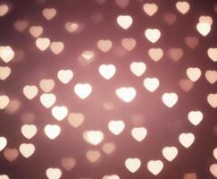 Pink blurred abstract background with cute bokeh hearts. photo