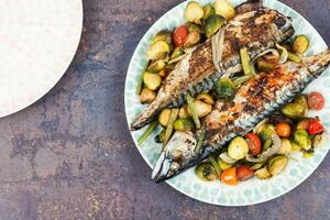 A la parrilla caballa pescado con vegetales. foto