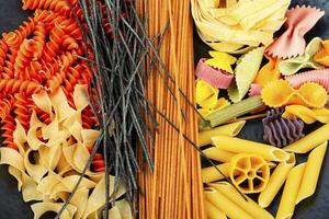 Plate with raw pasta and macaroni. photo