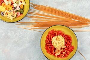 Bowl with raw pasta on cooking table photo