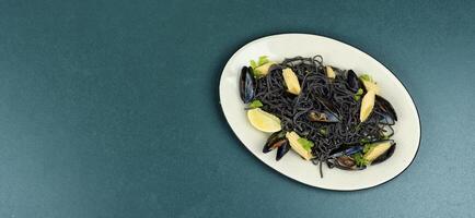 Black pasta with mussels and corn. photo