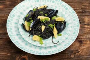 Black spaghetti pasta with mussels. photo