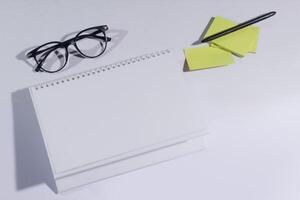 top view of desk calendar with blank green notes, white background photo