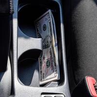 varios billetes americano dolares mentira en el nicho de el central consola de el coche. el dinero en el coche foto