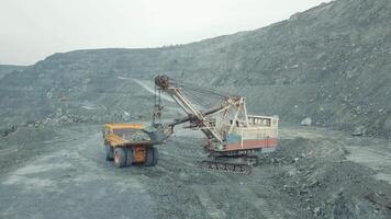 Excavator loads the limestone ore on a dump-body truck. Panoramic view. video