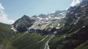 aérien vue de Montagne paysage. aérien vue de montagnes couvert forêt, des arbres avec écoulement rivière, contre le ciel et des nuages video