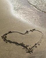 Heart drawn on the beach sand photo