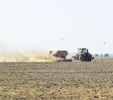 tractor paseos en el campo y hace el fertilizante dentro el asique foto