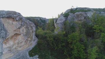 Close-up of a picturesque boulders with trees and green foliage. Shot. Wonderful view from the top of rocky hill. video