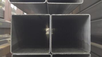 Stacked steel pipe with sunlight reflecting on the interior walls of central part. Rectangular metal pipe for construction. Pipes rectangular section. video